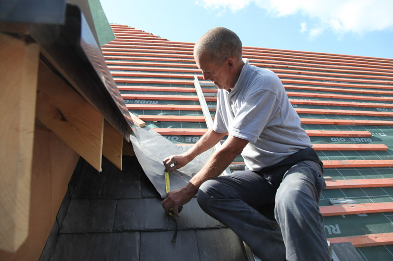 Mick Carter fixing tiles beside a dormer