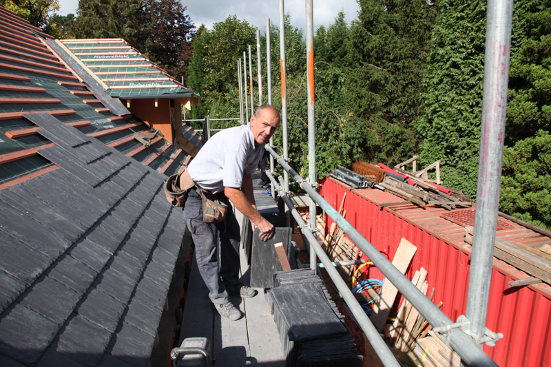 Mick Carter on the scaffold beside a slate roof