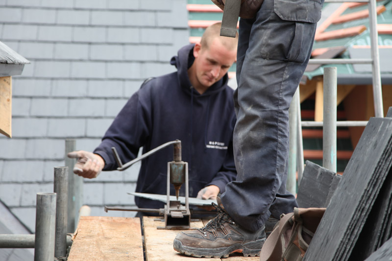 Paul Carter cutting slate on the scaffold